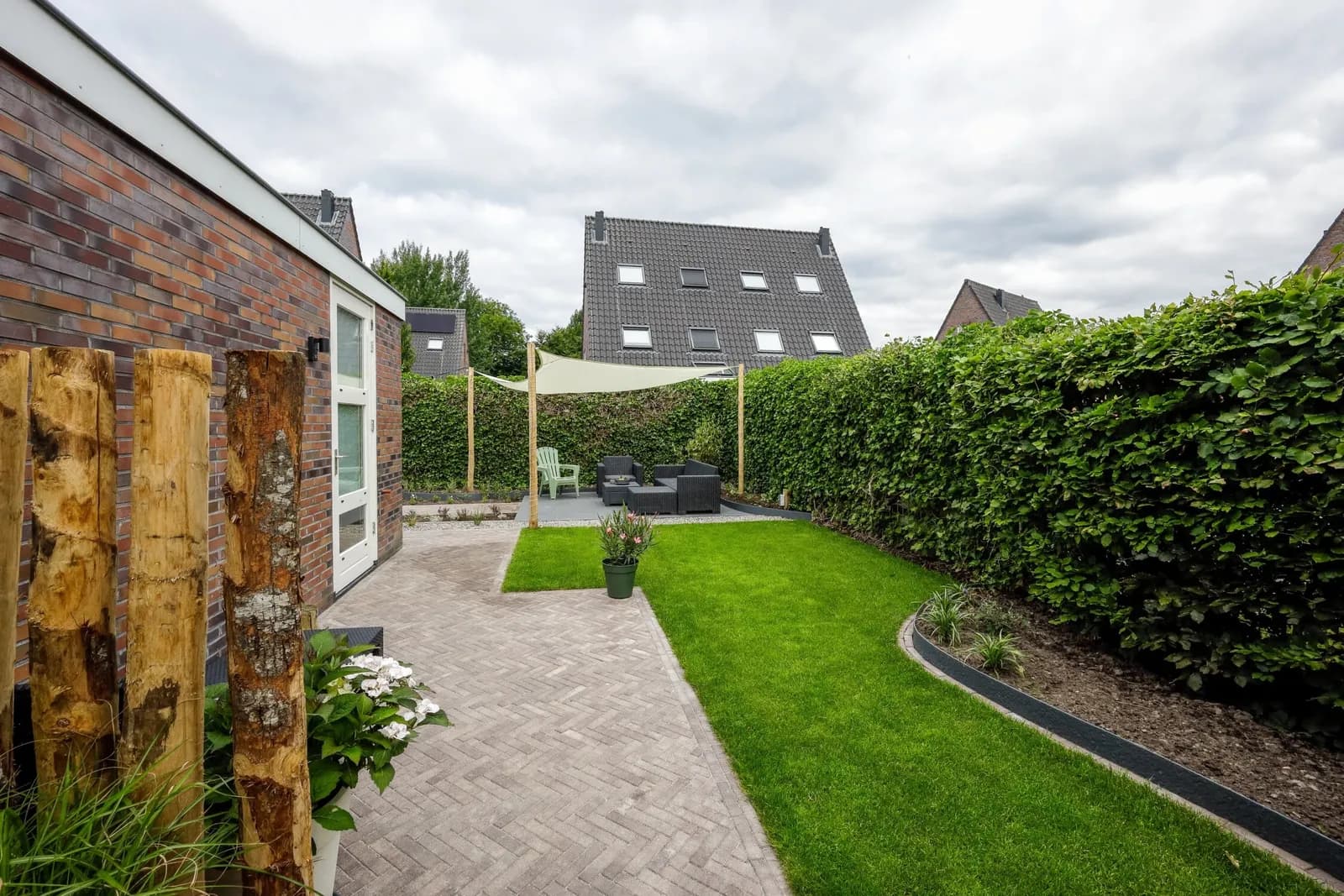 Sfeervolle tuin met betonnen muren van grind en kastanje zuilen.